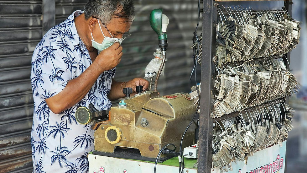 Asian locksmith operates a mobile key machine outdoors. Hardware business scene.