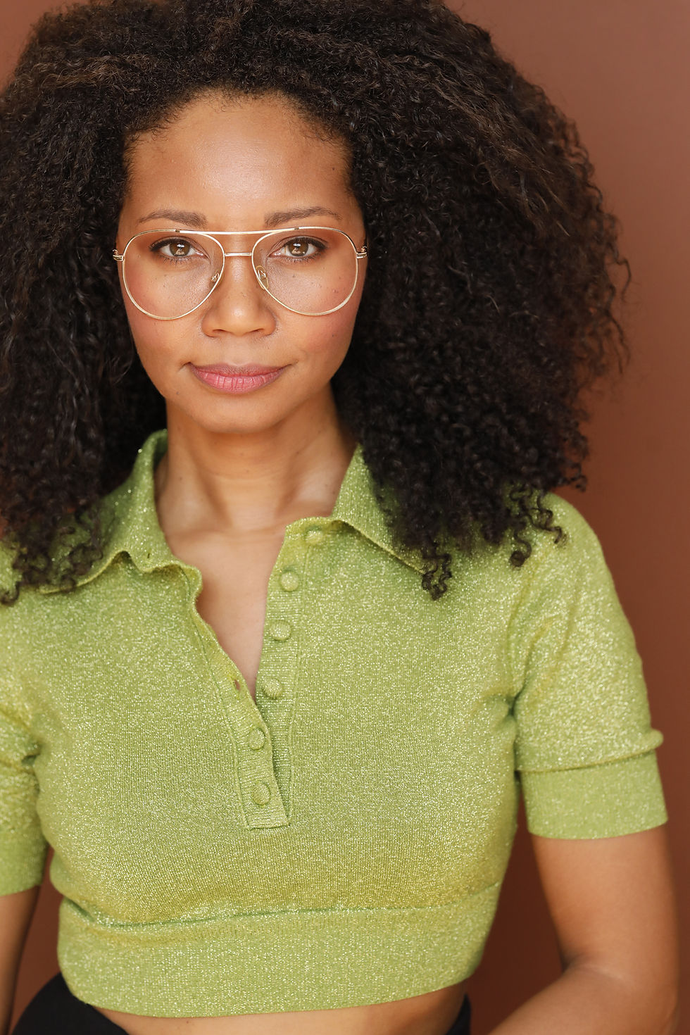 Aliza 70s headshot in lime green polo with aviator glasses