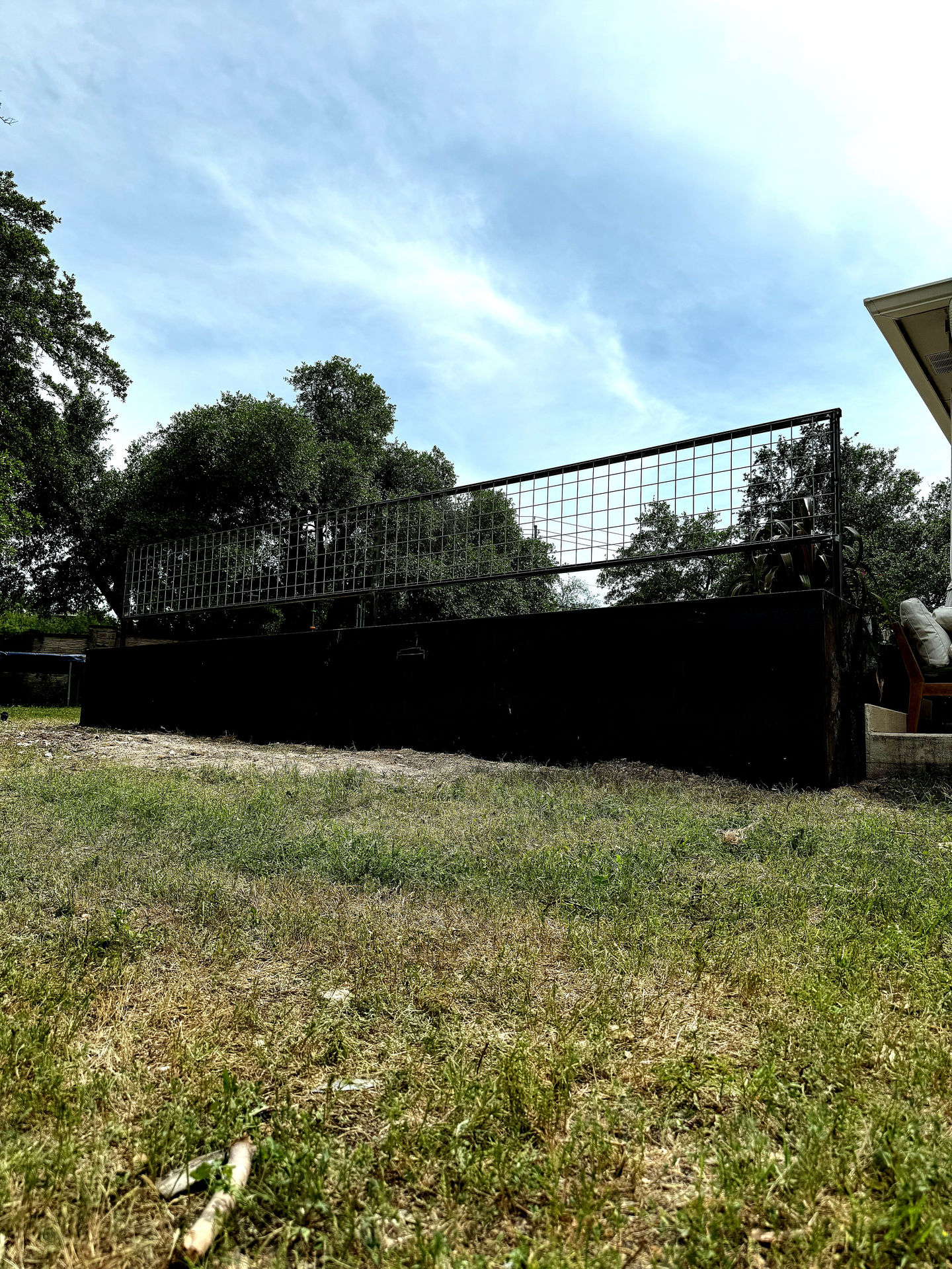 a backyard with a fence and trees in the background