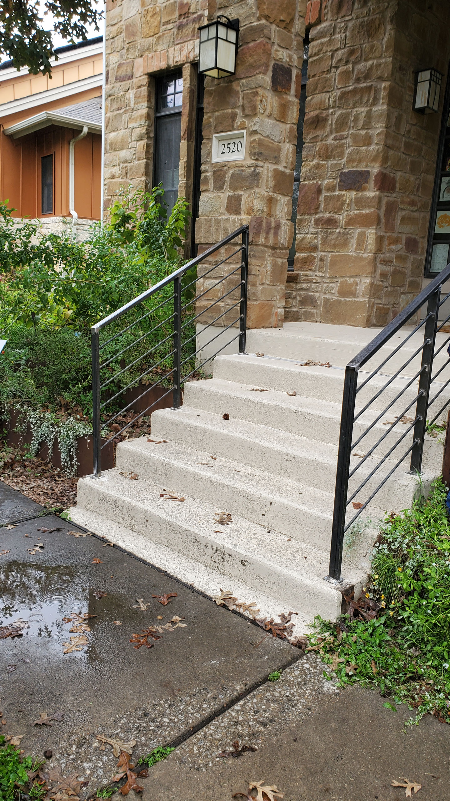 a set of concrete stairs with a black railing
