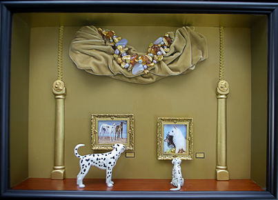 Dalmatian mother guides puppies through a dog-portrait gallery; amber-trimmed valence and tiny bulldog buttons add wit.