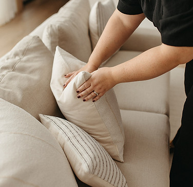 one of our designers fluffing a pillow