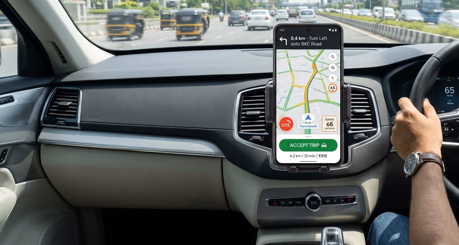 A driver's phone, mounted on the dashboard, shows a turn-by-turn navigation and trip screen while driving through city traffic.