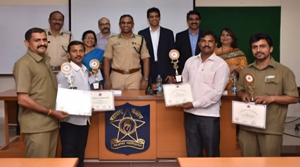 Professional drivers at a recognition ceremony with Maharashtra Police officials, holding certificates of excellence.