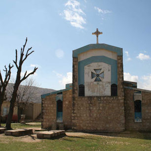 An old brick church building with blue features and small arched window holes