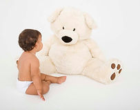 Image of a sitting baby with a huge cuddly bear