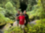 Three men, posing for picture in jungle