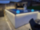 Modern garden with illuminated pool and seating area.