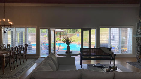 Large open Great Room & Dining Area with double doors opening out to the back patio and pool