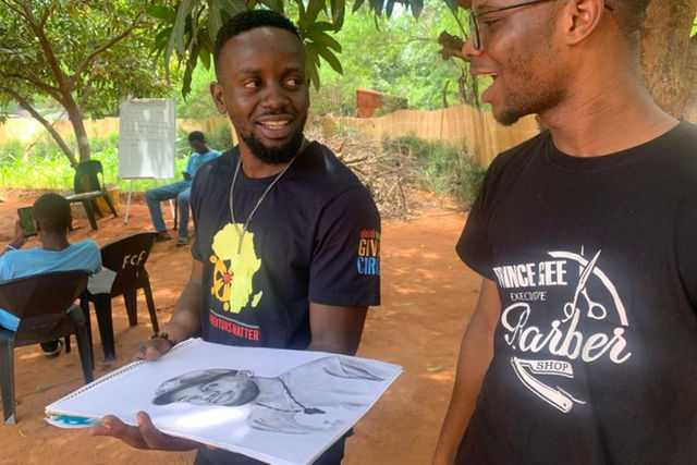Mentor Kangwa speaking to one of his mentees who gifted him with a portrait drawing