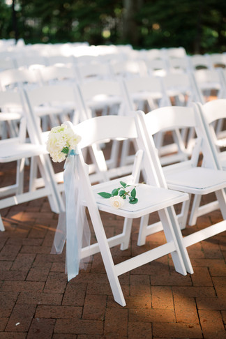 single long stem white roses on memory chair in new orleans wedding ceremony at audubon tea room