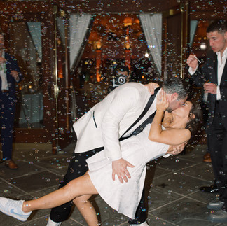 bride and groom sharing a kiss at their bubble grand exit