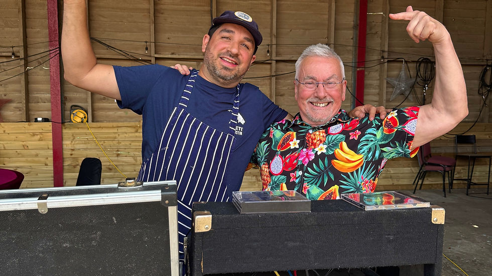 Two DJs with decks set up in the barn.