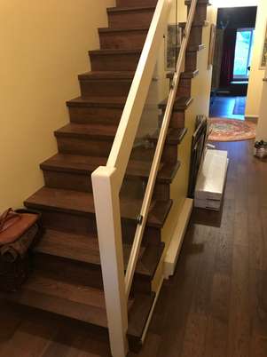 Wooden staircase with a modern glass and cable railing system.