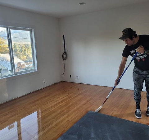 Hank from Kwatna Flooring applying a coat to a newly refinished hardwood floor