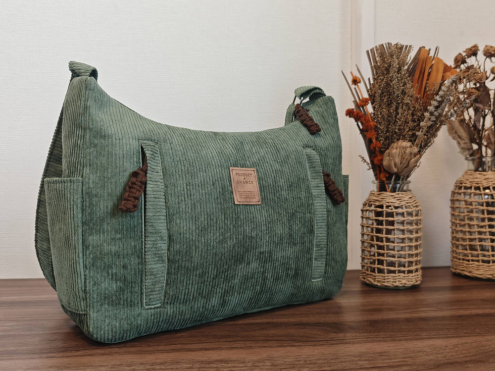 un sac bandoulière en velours côtelé vert avec sangle réglable et poches passepoilées