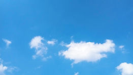 A blue sky with wispy white clouds