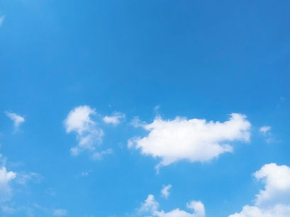 A blue sky with wispy white clouds