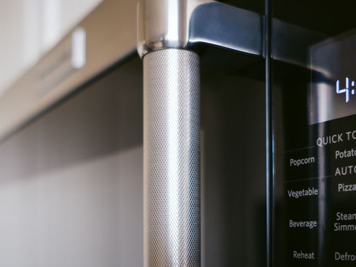 A close-up of a modern microwave oven shows its sleek design and digital display, highlighting various quick touch options for convenient cooking.