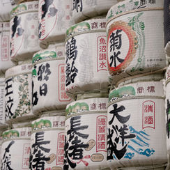 A display of traditional Japanese sake barrels, intricately decorated and stacked, often used for ceremonial purposes or as offerings at shrines.