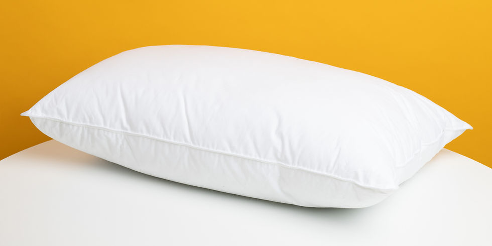A white pillow rests on a white surface against a vibrant yellow background. The scene is simple and serene, highlighting the pillow's soft texture.