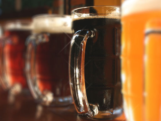 A lineup of beer mugs showcasing a range of rich, vibrant colors from amber to deep brown, inviting a taste of diverse flavors.