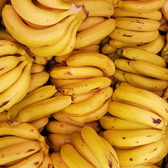 A vibrant display of ripe bananas, their bright yellow hue and slight brown speckles signaling peak freshness, arranged invitingly for shoppers.