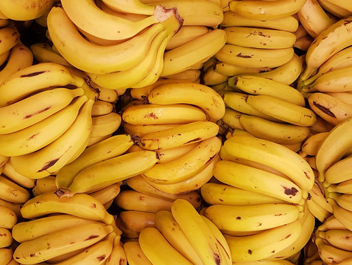 A vibrant display of ripe bananas, their bright yellow hue and slight brown speckles signaling peak freshness, arranged invitingly for shoppers.