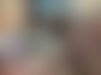 Various yarns in soft pastels and white fill a bin, with visible labels reading "Bernat" and "Softee Baby." The mood is cozy and creative.