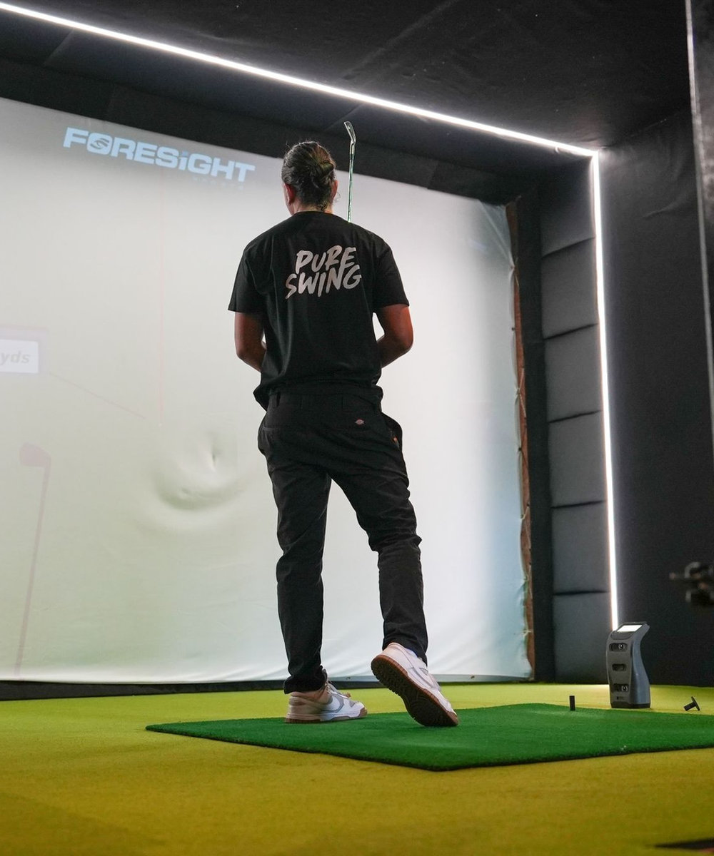 Playing a simulator bay at Pure Swing