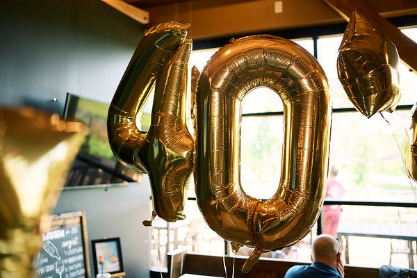 Gold 40 balloons float inside a bright wine bar by a window. Wild Crush in St. Louis. Photo by Corey Allen Photography