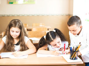 Niños en pupitre recibiendo clases.