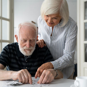 Pareja de la tercera edad armando un rompecabezas.