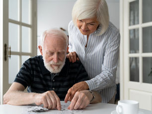 Pareja de la tercera edad armando un rompecabezas.