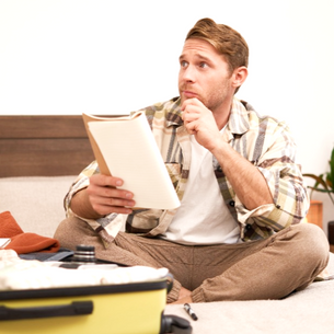 Viajero pensativo haciendo su maleta.