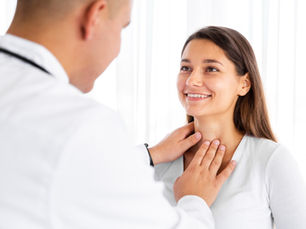 Médico realizando revisión de tiroides en mujer joven.