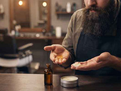 Hombre con barba comparando bálsamo para barba y aceite para barba en barbería