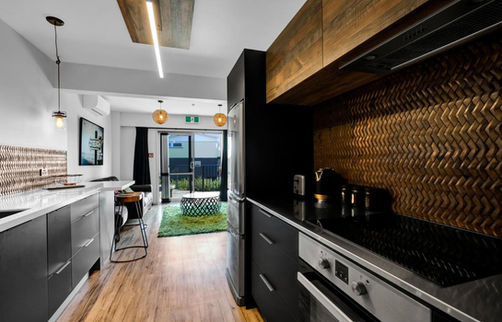 Sleek kitchen with oven and view into adjacent living room