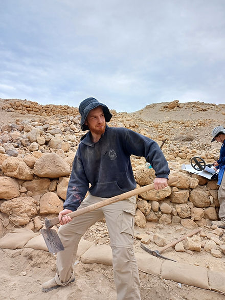 Young archaeologist using pickaxe at the En-Gedi Oasis dig site