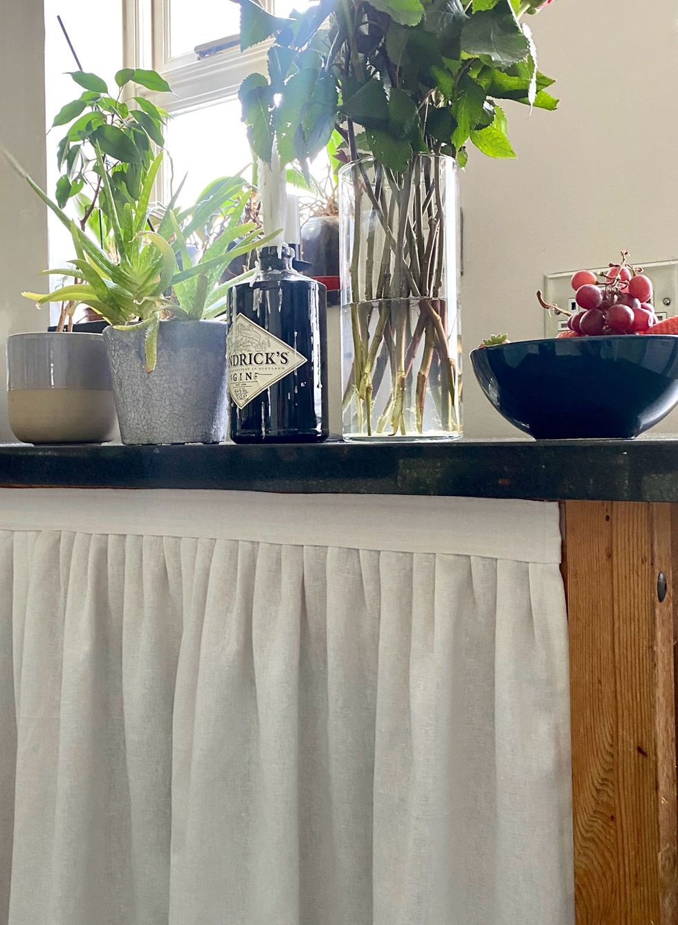 Thumbnail: white linen skin skirt with flowers, fruit and a bottle of Hendrick's gin