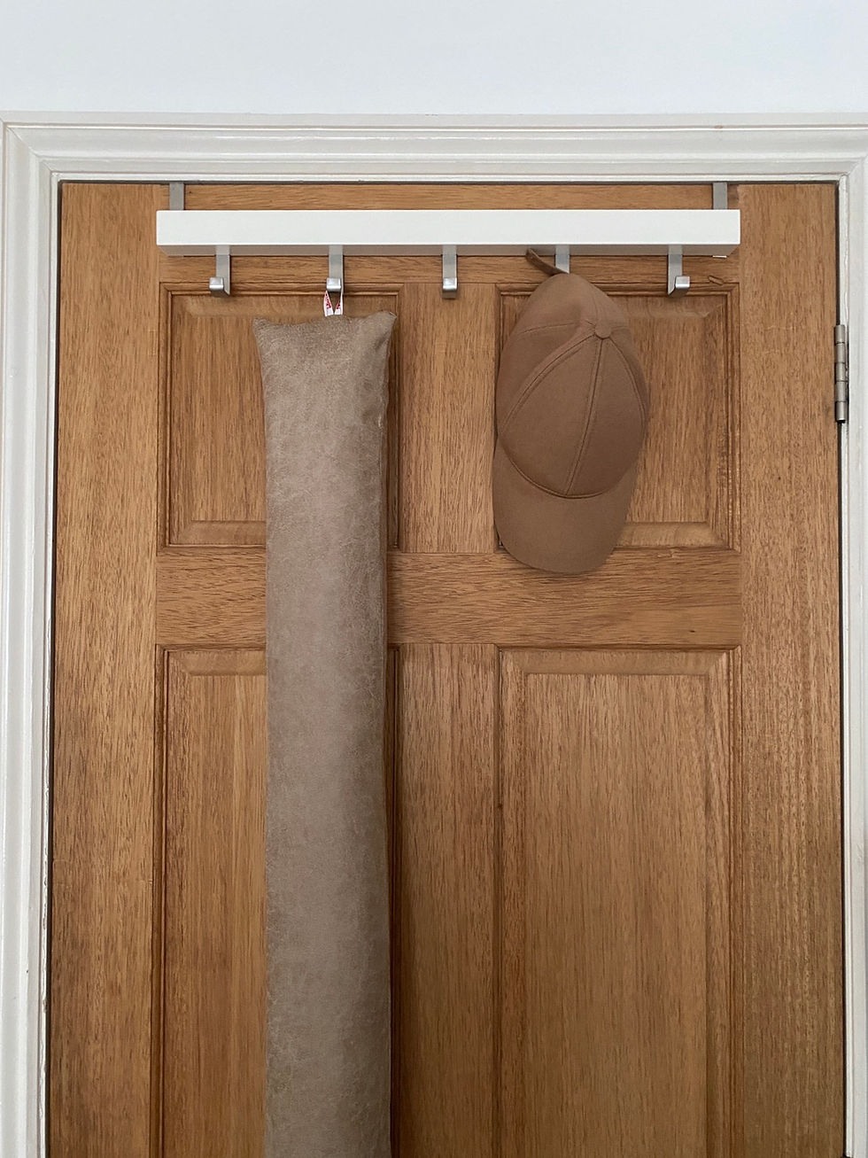 Thumbnail: vegan leather draft stopper hanging from door.