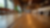 Eye-level view of a solid wood dining table with natural grain and sturdy legs in a restaurant setting