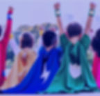 Children dressed as superhero's, with their hands in the air