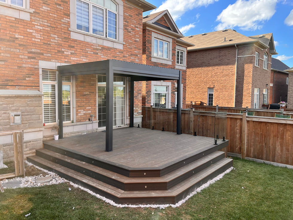 Contemporary backyard deck with aluminum pergola attached to brick house