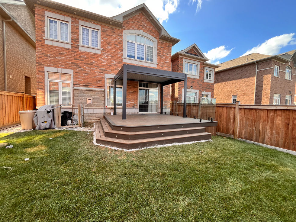 High-end composite deck installation with glass railing and pergola