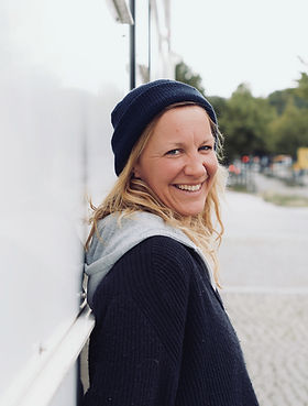 Portrait einer lächelnden warmherzigen Frau Mitte 30 mit Seemannstroyer und blauer Mütze