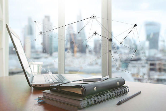 Un ordinateur portable, un agenda et un téléphone portable sur une table