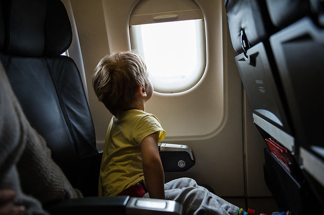 Un enfant assis dans un avion regardant par la fenêtre