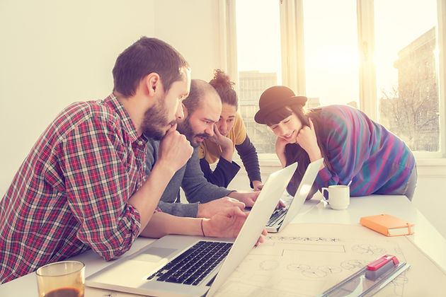 Groupe d'amis tous regardant le même écran d'ordinateur portable
