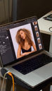 Beauty portrait of a model with curly hair displayed on a laptop during a studio photoshoot.